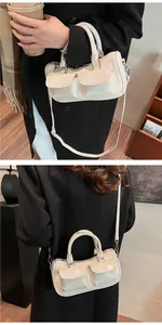 Detail view of cream white saddle bag showing double flap pockets and shiny leather finish