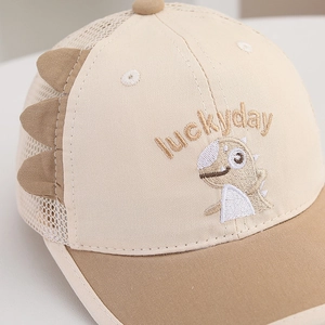 Détail de casquette en maille pour enfant avec broderie dinosaure et texte luckyday