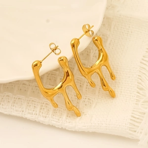 Elegant gold plated stainless steel earrings with unique liquid lava drop design on fabric