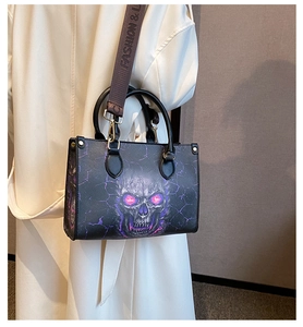 Detail of black skull tote bag featuring purple crackle print and wide fashion strap