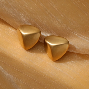 Macro shot of 18k gold plated geometric triangle earrings with matte brushed finish texture