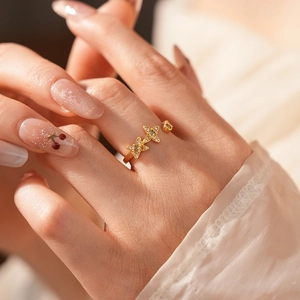 Détail d'une bague vintage dorée avec trois étoiles ornées de zircons verts et clairs