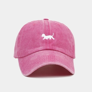 Détail de la broderie chien sur une casquette de baseball vintage rouge rose délavé