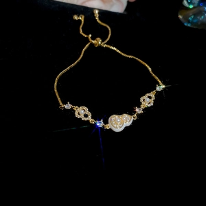 Detailed close-up of 18k gold plated gourd charm bracelet with pearls and zircon stones