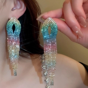 Close-up of sparkling colorful gradient rhinestone tassel earrings worn by a model