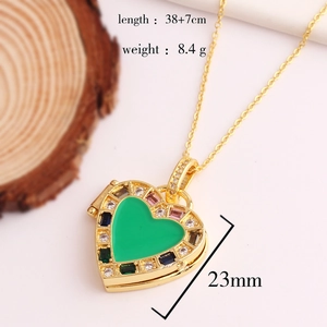 Macro view of gold heart necklace with green gem and colorful zircon inlay details