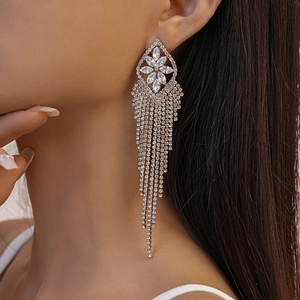Close-up of geometric flower tassel earrings with sparkling rhinestones on model