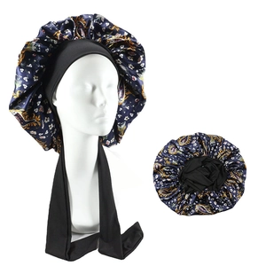 Detail of navy blue paisley satin sleep bonnet showing wide elastic tie and silky texture