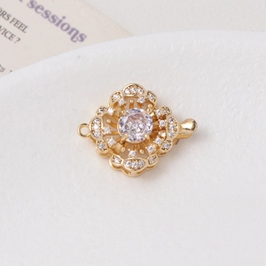 Macro shot of gold-plated flower clasp with micro-set zircon and pearl toggle detail