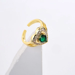 Macro detail of 18K gold plated ring featuring a heart-shaped green stone and baguette gems