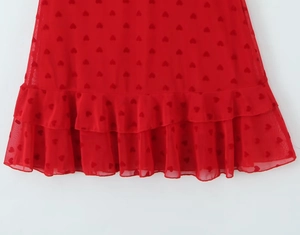 Détail de l'ourlet à volants double couche avec imprimé cœur sur tulle rouge
