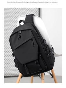 Detailed close-up of a black multi-pocket nylon travel backpack with secure strap design