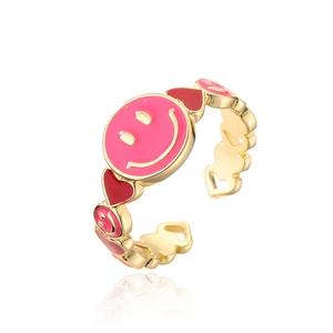 Detail view of gold adjustable ring featuring pink smiley face and red heart enamel charms