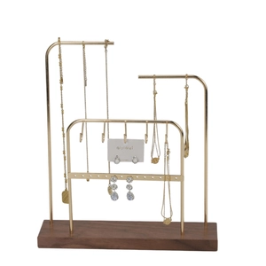 Detail of multi-tier gold metal jewelry stand with walnut wood base and earring organizer
