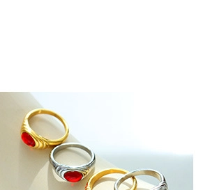 Detailed close-up of gold and silver plated rings with red oval gemstone insets