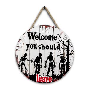Detail of round Halloween wooden welcome sign with zombie and dry tree silhouettes