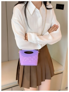 Vista dettagliata della mini borsa trapuntata viola con catena dorata su modella