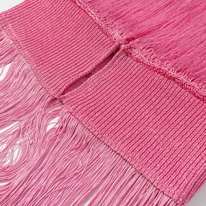 Close-up of pink knit fabric with long fringe details and premium woven texture