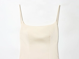 Close-up of cream satin dress featuring fine spaghetti straps and precise stitching detail