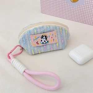 Detail of blue tweed earphone case with cartoon dog patch and pink lanyard hook