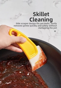 Grattoir de cuisine flexible nettoyant les résidus dans une poêle sur fond marbre