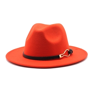 Detail of a bright orange fedora hat featuring a black band and gold metallic buckle