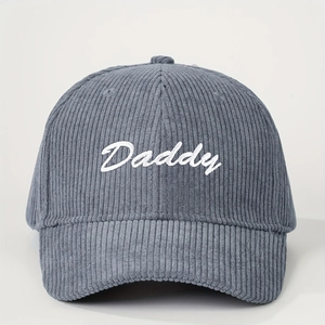 Close-up of dark grey corduroy baseball cap with white Daddy script embroidery