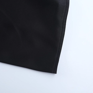 Close-up of black satin dress fabric showing precise stitching and smooth silk texture