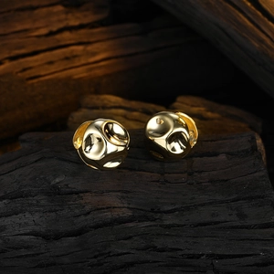 Minimalist irregular golden hoop earrings with ripple texture on dark wood background
