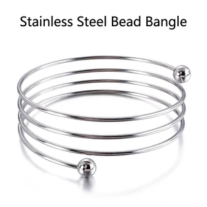 Polished stainless steel multi-layer spiral bangle featuring solid lucky beads at both ends