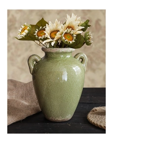 Detail van vintage keramische vaas met craquelé glazuur, handgrepen en zonnebloem