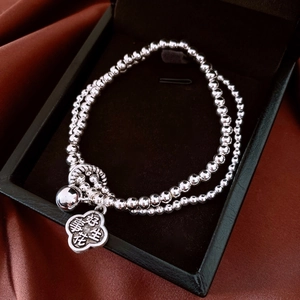 Macro shot of silver double-layered beaded bracelet with peanut charm in a jewelry box