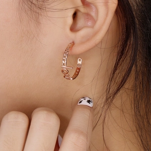 Close-up of rose gold C-shaped hoop earring with Cuban chain link and LOVE lettering