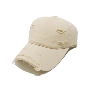 Close-up detail of vintage distressed baseball cap with ripped effects and washed fabric