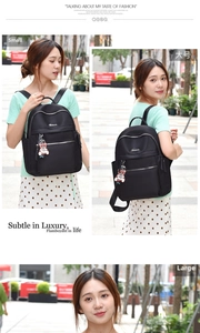 Detail view of black Oxford fabric backpacks in small and large sizes with bear pendant