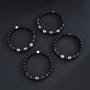 Detail of four black lava stone beaded bracelets with custom engraved silver metal tags