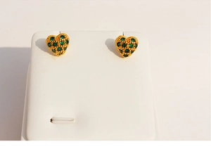 Detail of heart-shaped gold studs with micro-pave green zircon stones on display