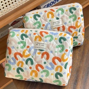 Detail of soft quilted fabric cosmetic bag with colorful U-pattern and metal zipper
