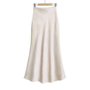 Détail d'une jupe longue à taille haute en satin brillant de couleur crème soyeuse