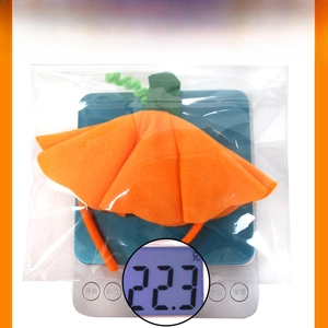 Detailed view of Halloween pumpkin headband on digital scale showing weight of 22.3g