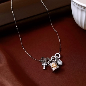 Detail view of silver cross and drop zircon pendants on a vintage necklace chain