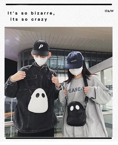 Street style shot of models wearing ghost-shaped crossbody bags in black and white leather