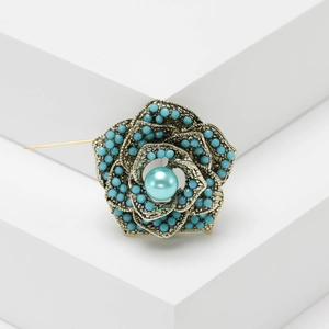 Vintage Turkish flower brooch with turquoise beads and pearls on white geometric background