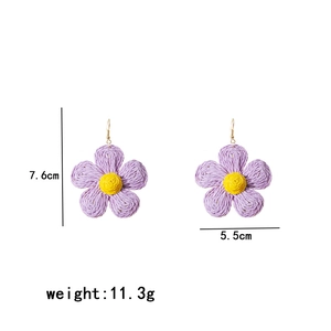 Detail showing dimensions of purple woven raffia flower earrings at 7.6cm by 5.5cm