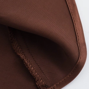 Detailed close-up of dark brown twill fabric with high-quality edge stitching and texture