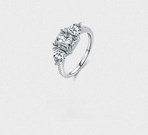 Detail of S925 silver ring featuring emerald cut center stone and pear side diamonds