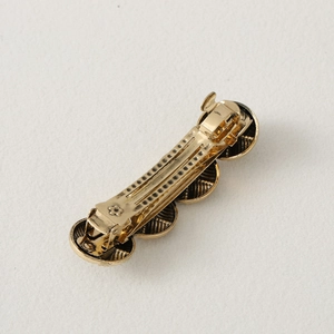 Detailed close-up of a vintage golden irregular round metallic hair clip for women