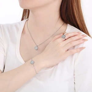 Detailed view of silver clover jewelry set featuring necklace bracelet and ring on model