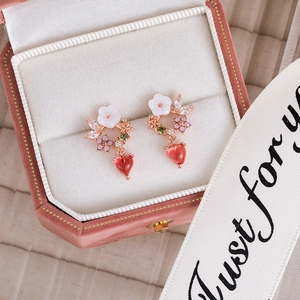 Close-up of floral heart earrings with pink zircons in a velvet jewelry gift box