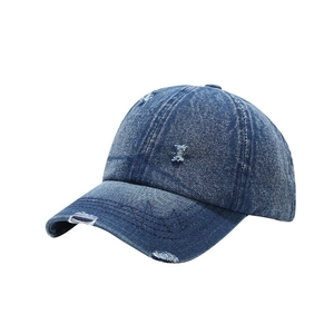 Distressed navy blue denim baseball cap with vintage frayed holes and retro street style